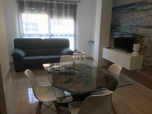 a living room with a glass table and a couch at El Piset del Llangosti in Vinaròs