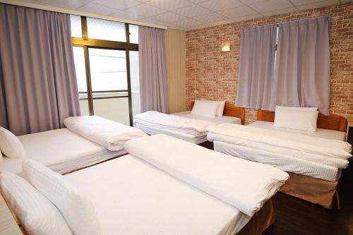 a room with four beds and a window at Zhongshan Hostel in Fenchihu