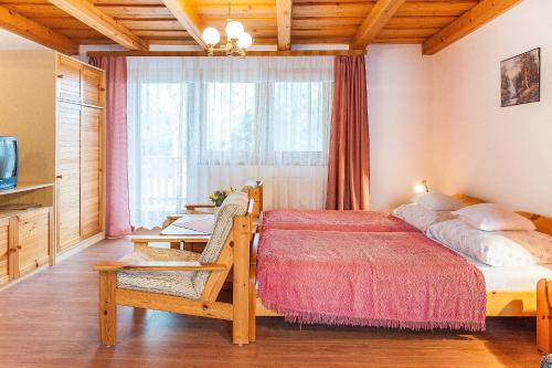 - une chambre avec un lit, une table et une fenêtre dans l'établissement ALina Apartmanház, à Hévíz