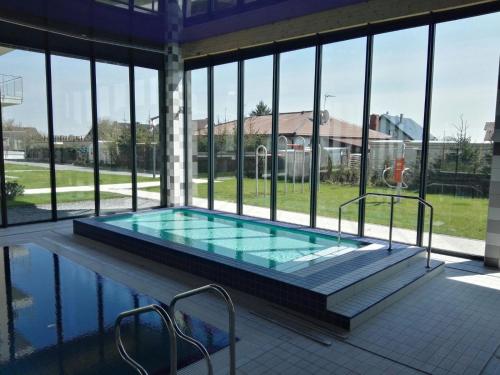 - une piscine dans un bâtiment avec fenêtres dans l'établissement Apartament Nadmorski - Kompleks Pięć Mórz z basenem, à Sianożęty