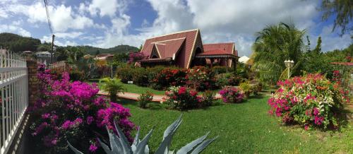 a house with flowers in front of a yard at Les bungalows de la plage in La Trinité