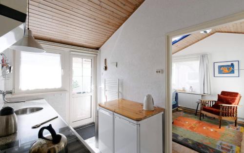 ベルゲンにあるholiday cottage 'FLOW'の白い壁と木製の天井のキッチン