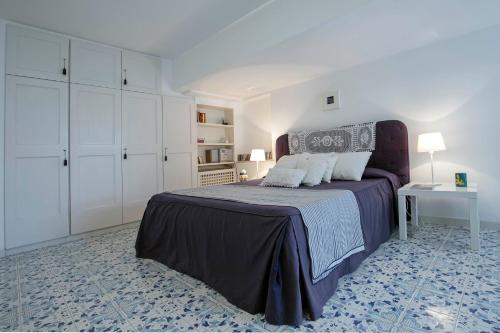 a bedroom with a bed and a table and white cabinets at Villa dei Limoni con terrazza e discesa a mare in Erchie