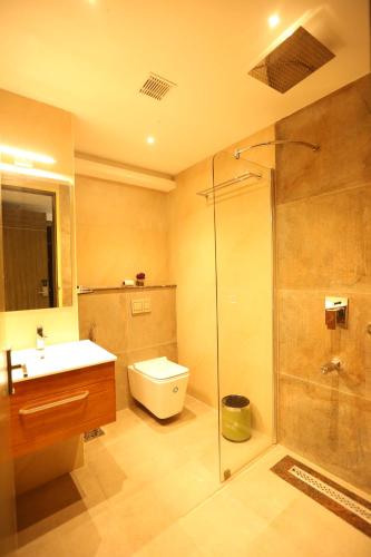 a bathroom with a shower and a toilet and a sink at Hotel Jump In & Out in Coimbatore