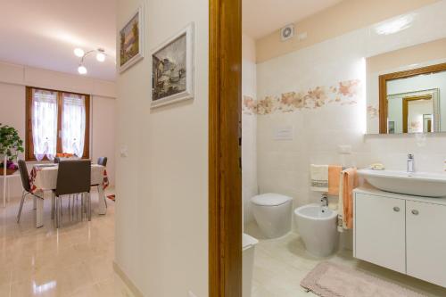 a bathroom with a sink and a toilet and a table at Giardino dei Limoni in Toscolano Maderno