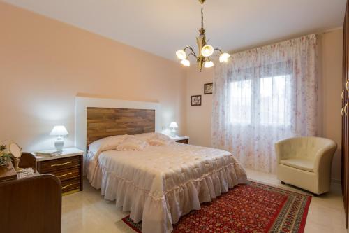 a bedroom with a bed and a chair and a window at Giardino dei Limoni in Toscolano Maderno