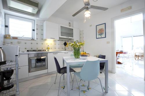 a kitchen with a table and chairs and a kitchen with appliances at Villa dei Limoni con terrazza e discesa a mare in Erchie