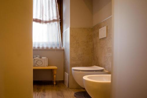a bathroom with a toilet and a sink and a window at Ca' Baetti l'Antica Corte in Roncola