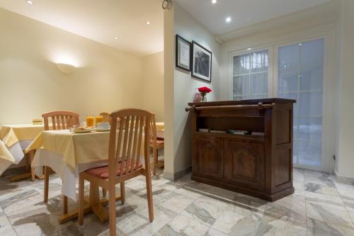 a dining room with a table and a piano at Le Home in Vincennes
