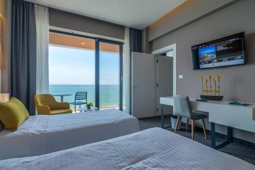 een hotelkamer met 2 bedden, een bureau en een raam bij Nyota Hotel & Conference Center in Mamaia