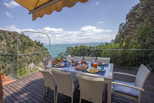 a table and chairs on a deck with a view of the ocean at Villa dei Limoni con terrazza e discesa a mare in Erchie