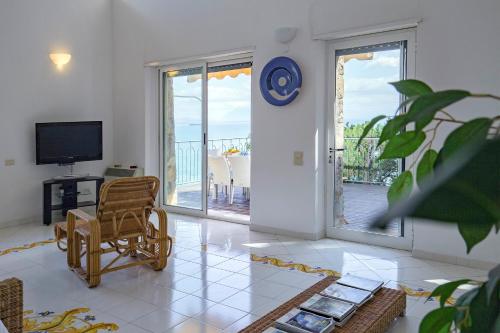 a living room with a tv and a chair and a television at Villa dei Limoni con terrazza e discesa a mare in Erchie