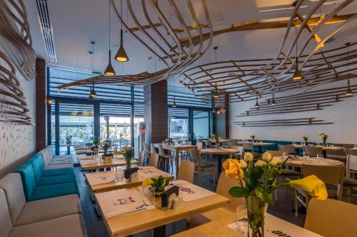 ein Restaurant mit Tischen, Sofas und Stühlen in der Unterkunft Nyota Hotel & Conference Center in Mamaia
