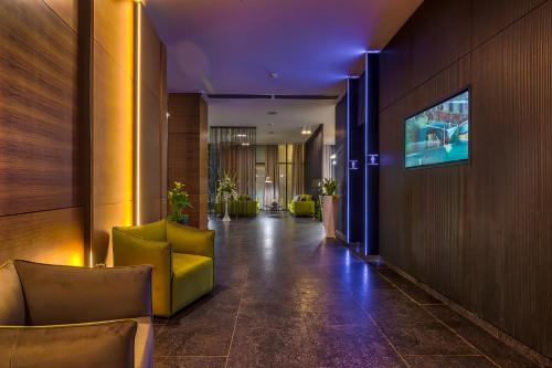 un corridoio con sedie e TV in un edificio di Nyota Hotel & Conference Center a Mamaia