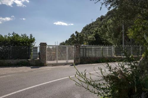 a gate on the side of a road with a fence at Villa dei Limoni con terrazza e discesa a mare in Erchie