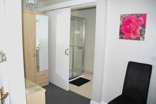 a bathroom with a mirror and a chair in a room at Brincliffe Hotel in Blackpool