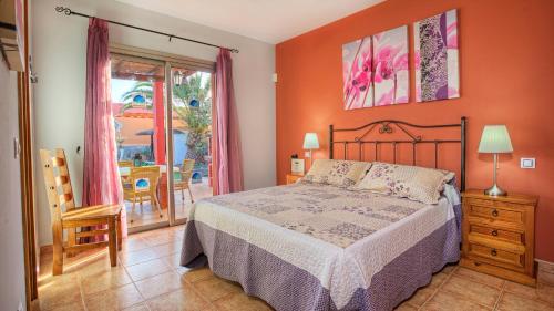 1 dormitorio con cama y vistas a un patio en Villa Romana, en Caleta de Fuste