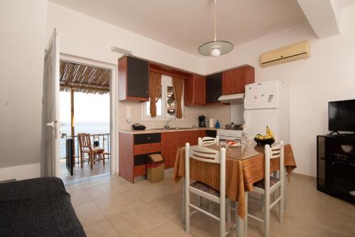 a kitchen with a table and a refrigerator at Beach View in Kaloi Limenes