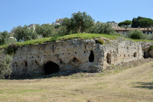 an old stone wall with a tunnel in a field at Antica Villa di Bruto in Tivoli