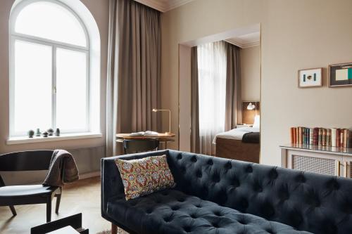 a living room with a couch and a bedroom at Hotel St. George Helsinki in Helsinki