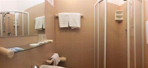 een badkamer met een douche, een toilet en een spiegel bij Hotel dell'Amarissimo in Bellaria-Igea Marina