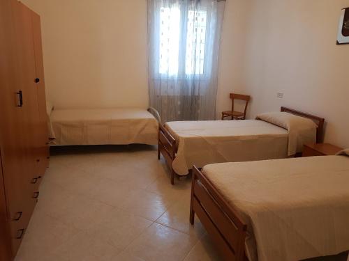 a room with two beds and a window at Casa in campagna in Cisternino