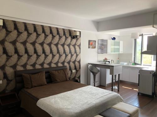 a bedroom with a bed and a table and a sink at Vlaicu Apartments in Constanţa