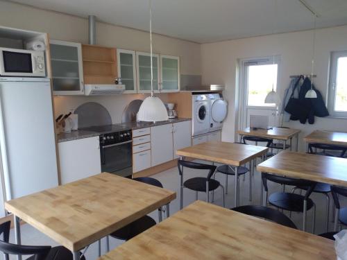 a kitchen with wooden tables and chairs in it at Motel Lyren in Padborg