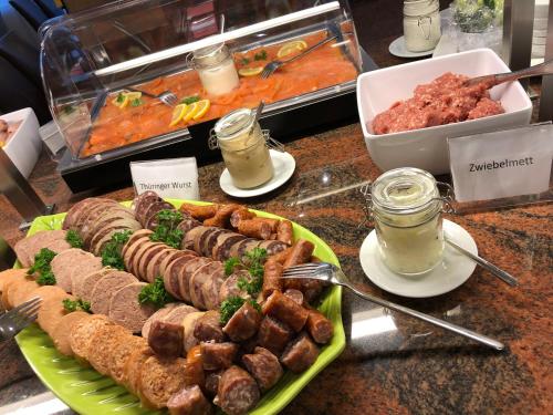 a buffet of food with sausage and meat on a counter at Göbel's Sophien Hotel in Eisenach