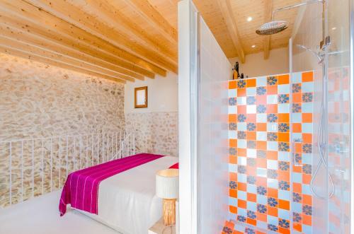 a bedroom with a bed and a shower at Casa Vella (Vall Petit) in Mancor del Valle
