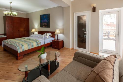 1 dormitorio con cama, sofá y mesa en Penthouse Hotel, en Tiflis