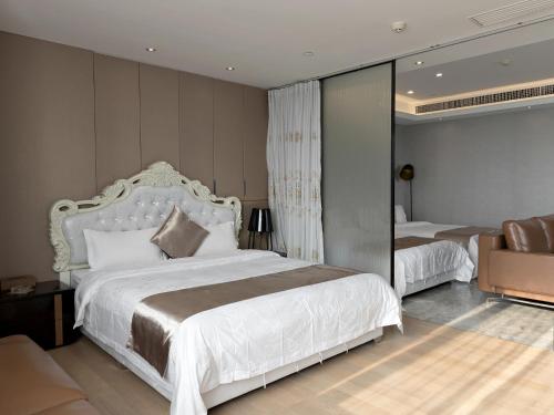 a bedroom with a large white bed and a chair at Pengman Beijing Road A-mall Apartment - Free Shuttle to Canton Fair in Guangzhou
