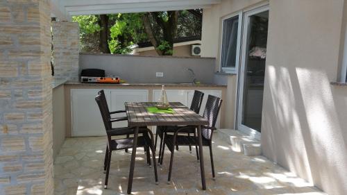 stół i krzesła na patio w kuchni w obiekcie Holiday Park Mimoza w mieście Bašanija