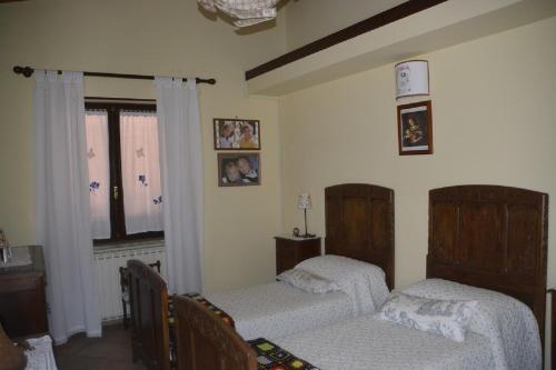 a bedroom with two beds and a window at Il Laghetto in Torre Canavese