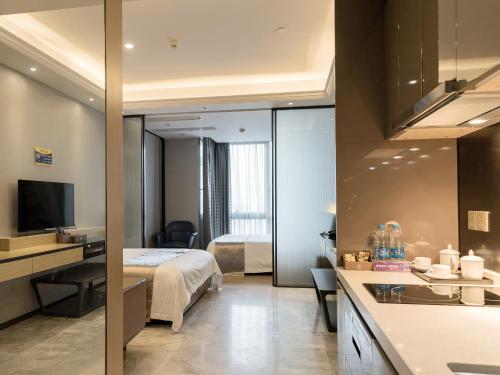 a hotel room with a bed and a bathroom at Pengman Beijing Rd. A-mall Apartment in Guangzhou