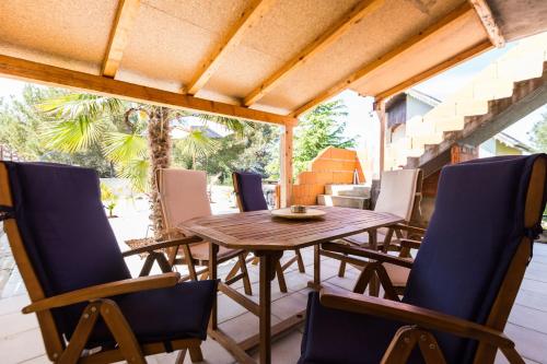 a wooden table and chairs on a patio at Holliday Home MaxDom in Sukošan