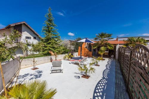 a patio with chairs and a christmas tree at Holliday Home MaxDom in Sukošan