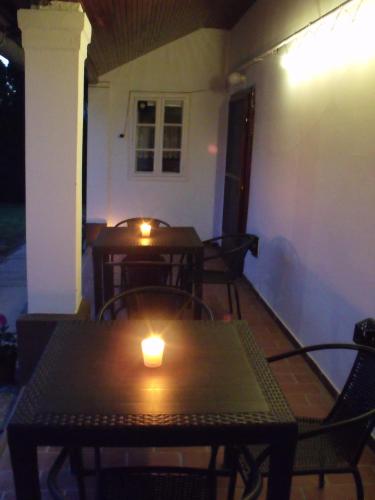 two tables and chairs with a candle on a patio at Feszty-fészek Vendégház in Tiszafüred