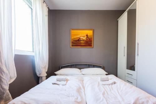 a bedroom with a large bed with white sheets at Holliday Home MaxDom in Sukošan