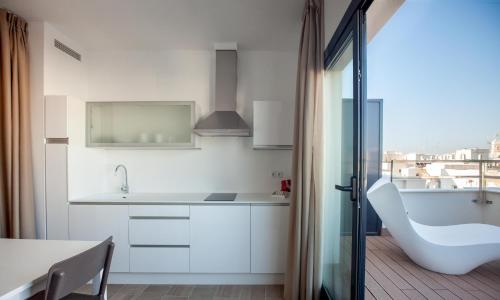 a white kitchen with a sink and a tub at Apartamentos Maier in Cádiz