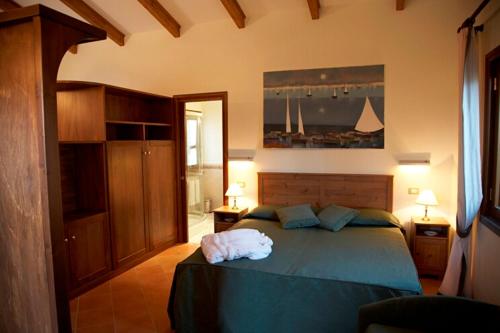 a bedroom with a bed with a blue comforter at Hotel O Sole Mio in SantʼAgata sui Due Golfi
