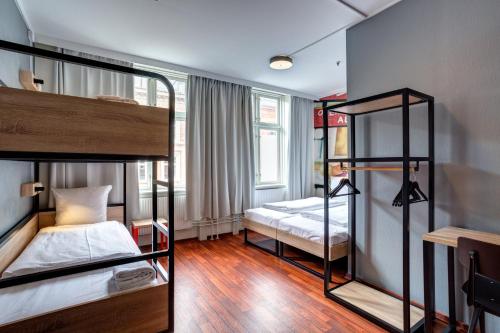 a room with two bunk beds and a window at Urban House Copenhagen by MEININGER in Copenhagen