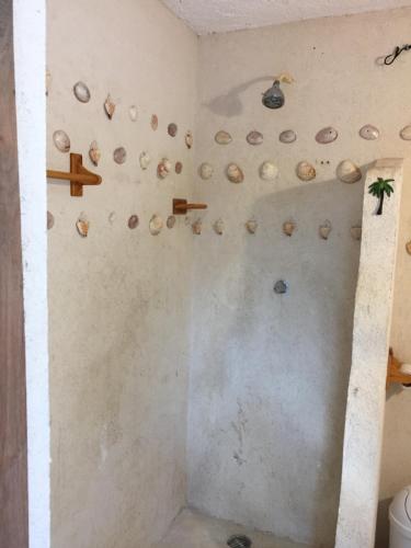 un baño con un montón de rocas en la pared en Playa las palmas, en Tulum