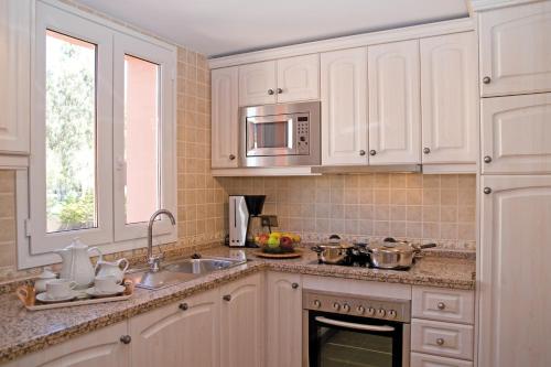 a kitchen with a stove top oven and a sink at Marbella Beach Resort at Club Playa Real in Marbella