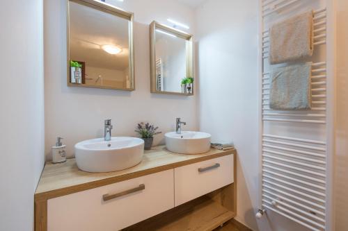 La salle de bains est pourvue de 2 lavabos et de 2 miroirs. dans l'établissement Apartman Alberti, à Labin
