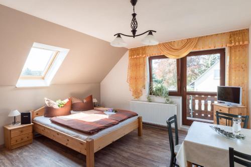 1 dormitorio con cama, mesa y ventana en Ferienwohnung Hetzdorf - Urlaub am Tharandter Wald, en Hetzdorf
