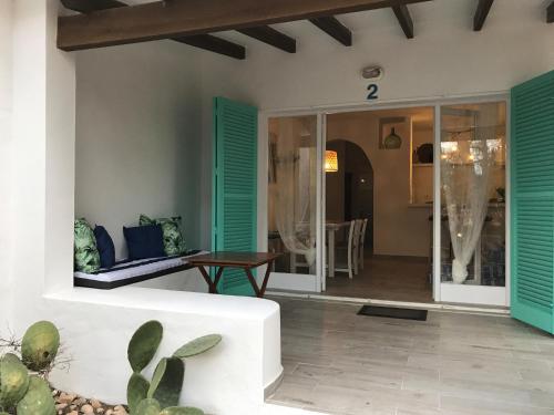a living room with a white couch and green shutters at Cabaña Cala Saona in Sant Francesc Xavier