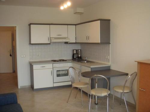 a kitchen with white cabinets and a table and chairs at Haus Baltic in Ostseebad Sellin