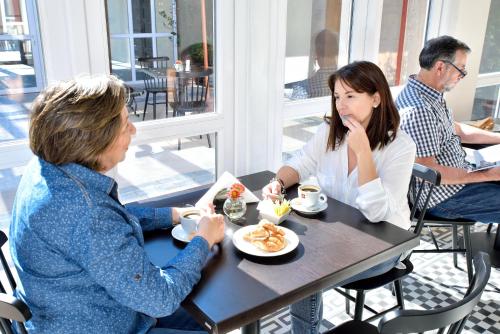 two women sitting at a table eating food at Lagar Hotel Boutique in Molina