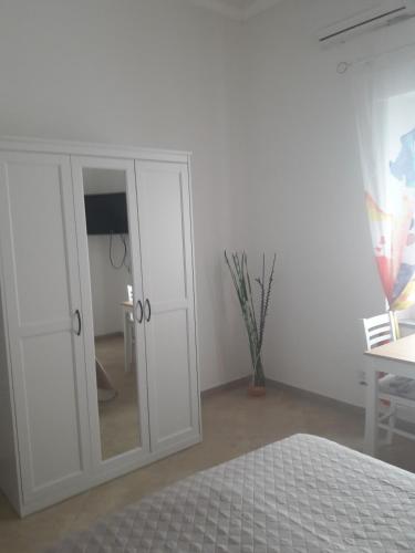 a bedroom with a white cabinet and a mirror at Casa Corona in Capoterra